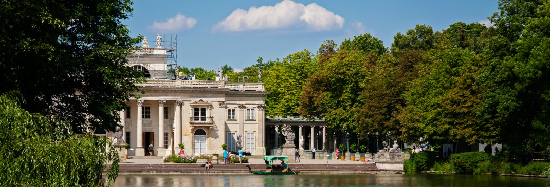 A red tourist boat travels down the Royal Baths in Warsaw